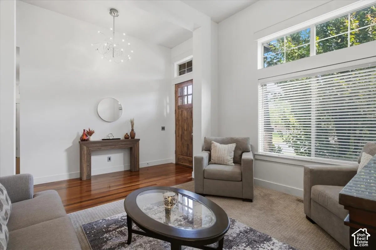Hardwood-finish flooring, high ceilings, large windows, and an ornate chandelier