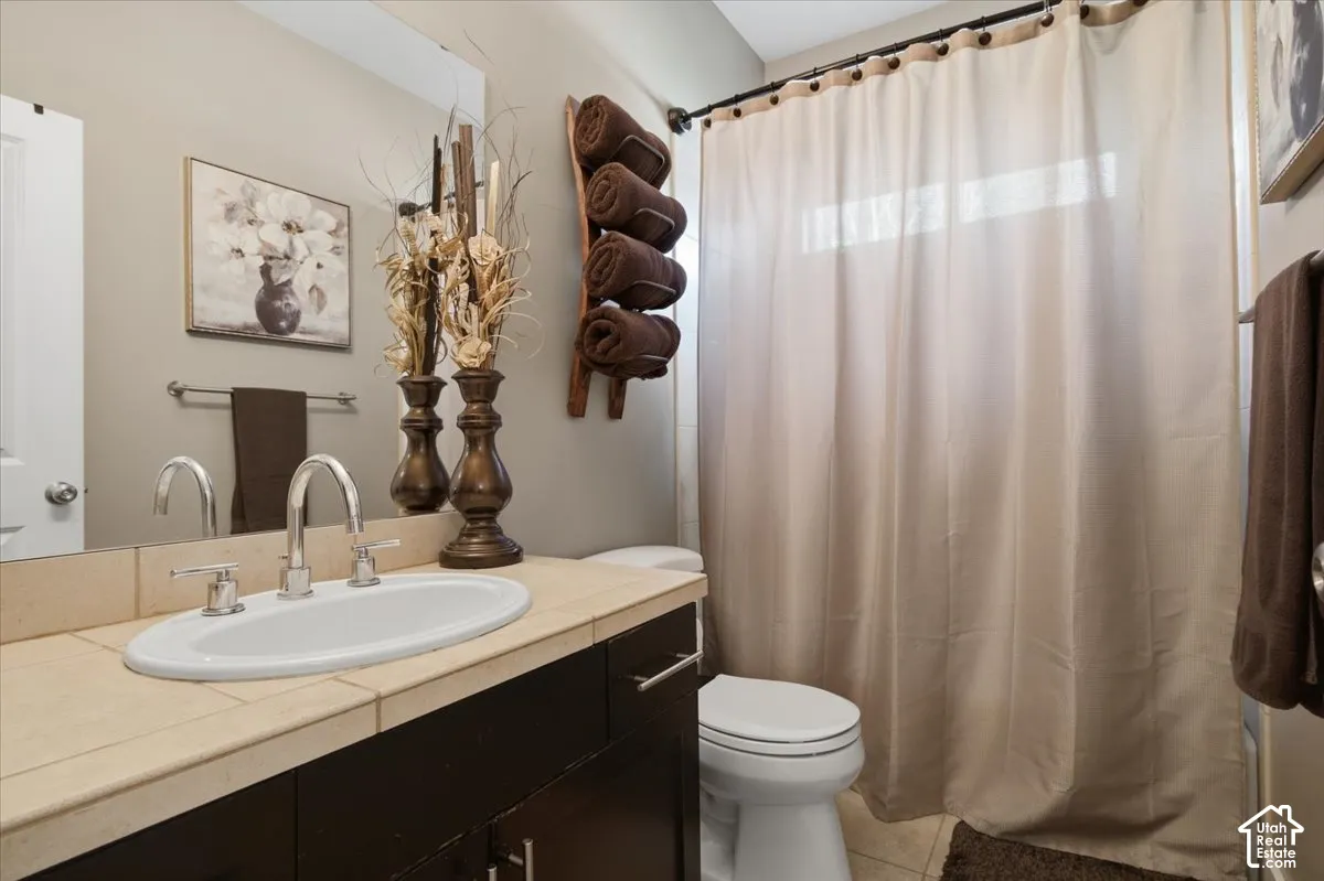 Bathroom featuring a dark wood-finish vanity, an oval undermount sink, a chrome two-handle faucet, and a large mirror