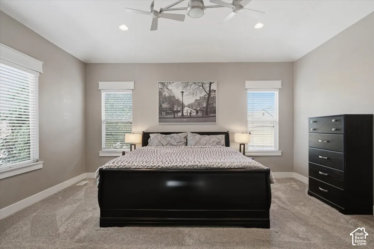 Vaulted ceiling with dual ceiling fans, recessed lighting, neutral tone walls, and twin windows with blinds
