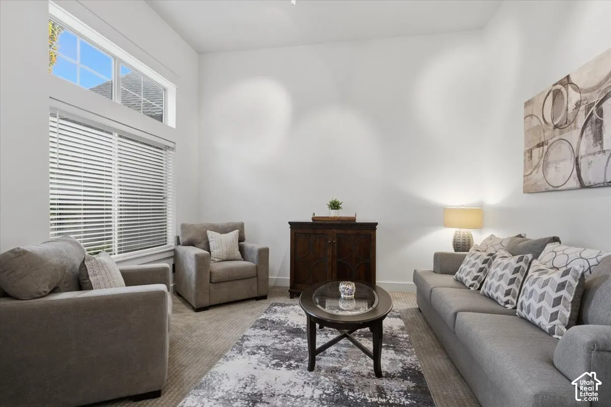High ceilings with upper transom windows, large window with blinds, and recessed lighting