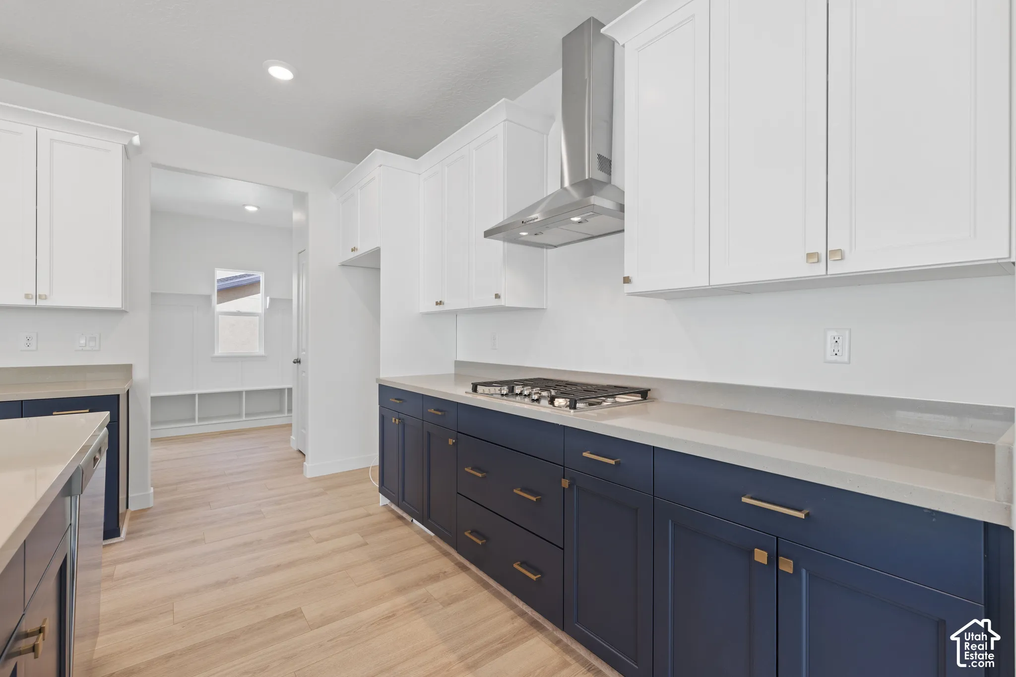 Modern kitchen featuring white upper cabinetry, navy lower cabinetry, and light-toned countertops