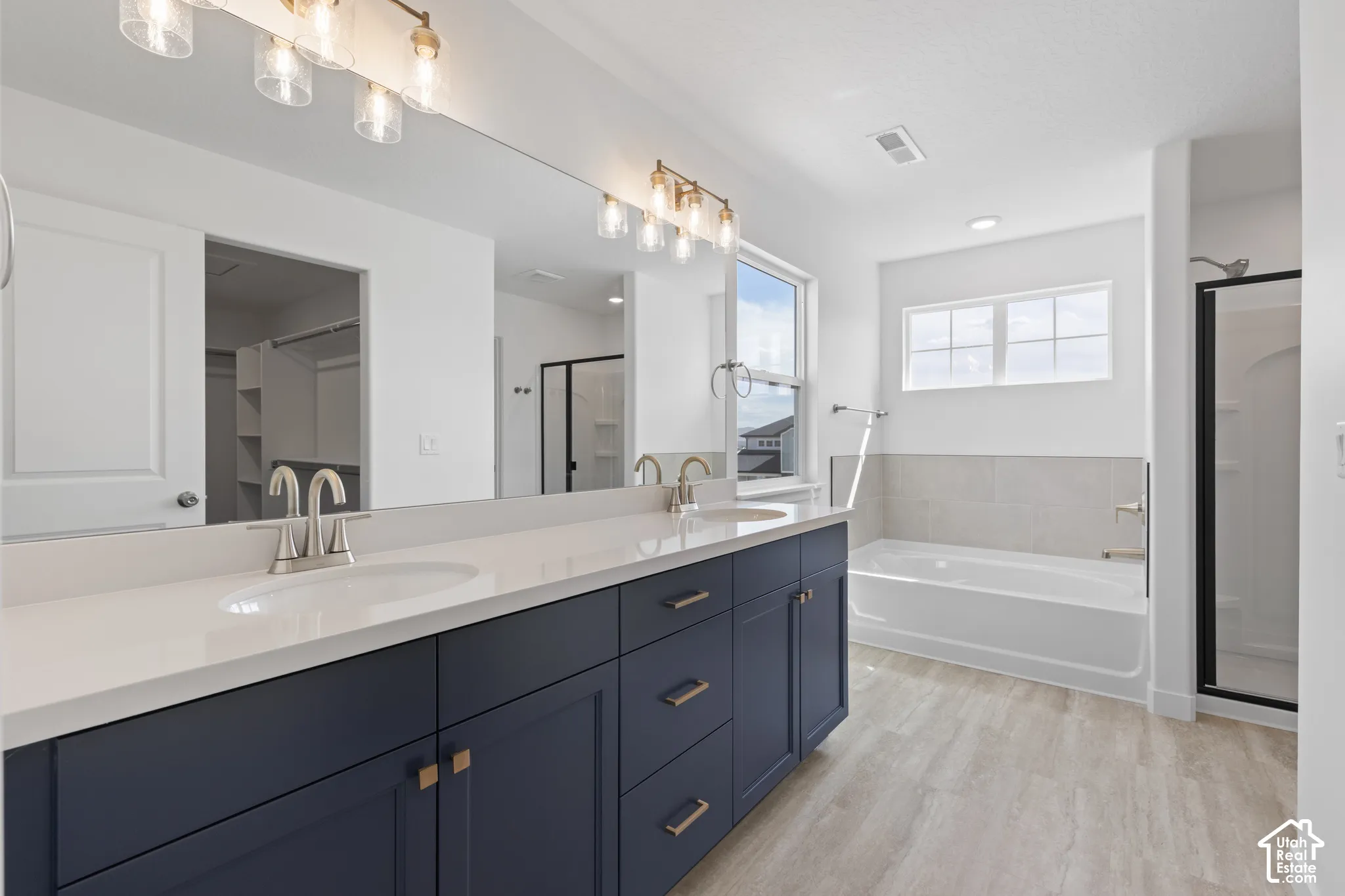 Dual vanity with crisp white countertops, deep blue cabinetry, and brushed nickel hardware