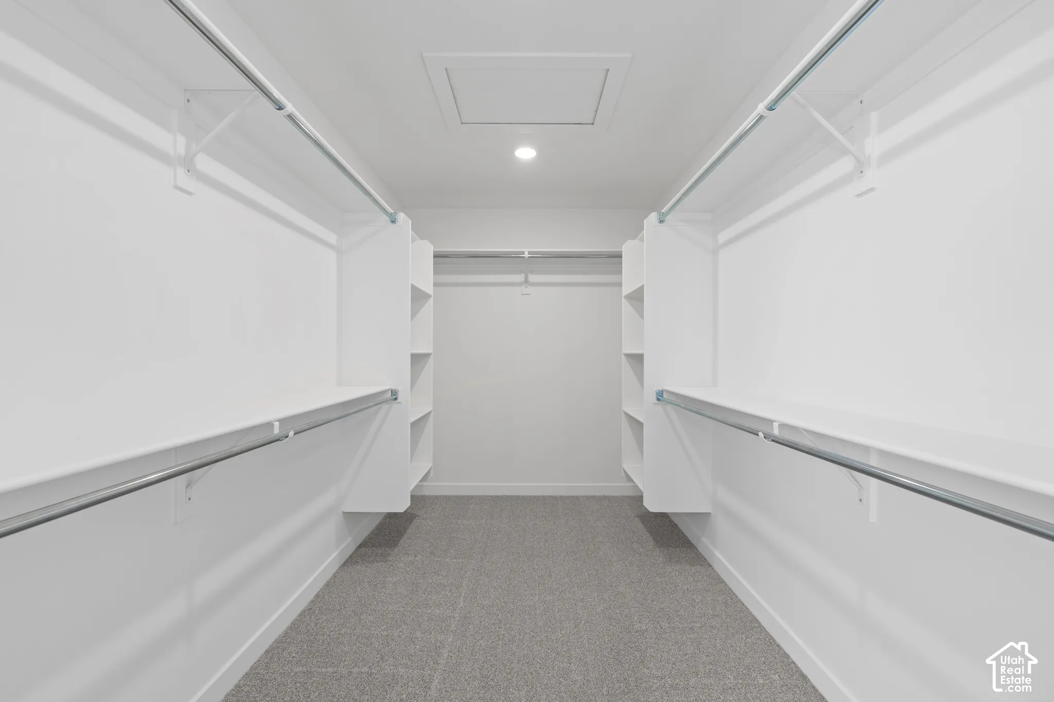Walk-in closet with carpet flooring, recessed lighting, white built-in shelving, and metal hanging rods