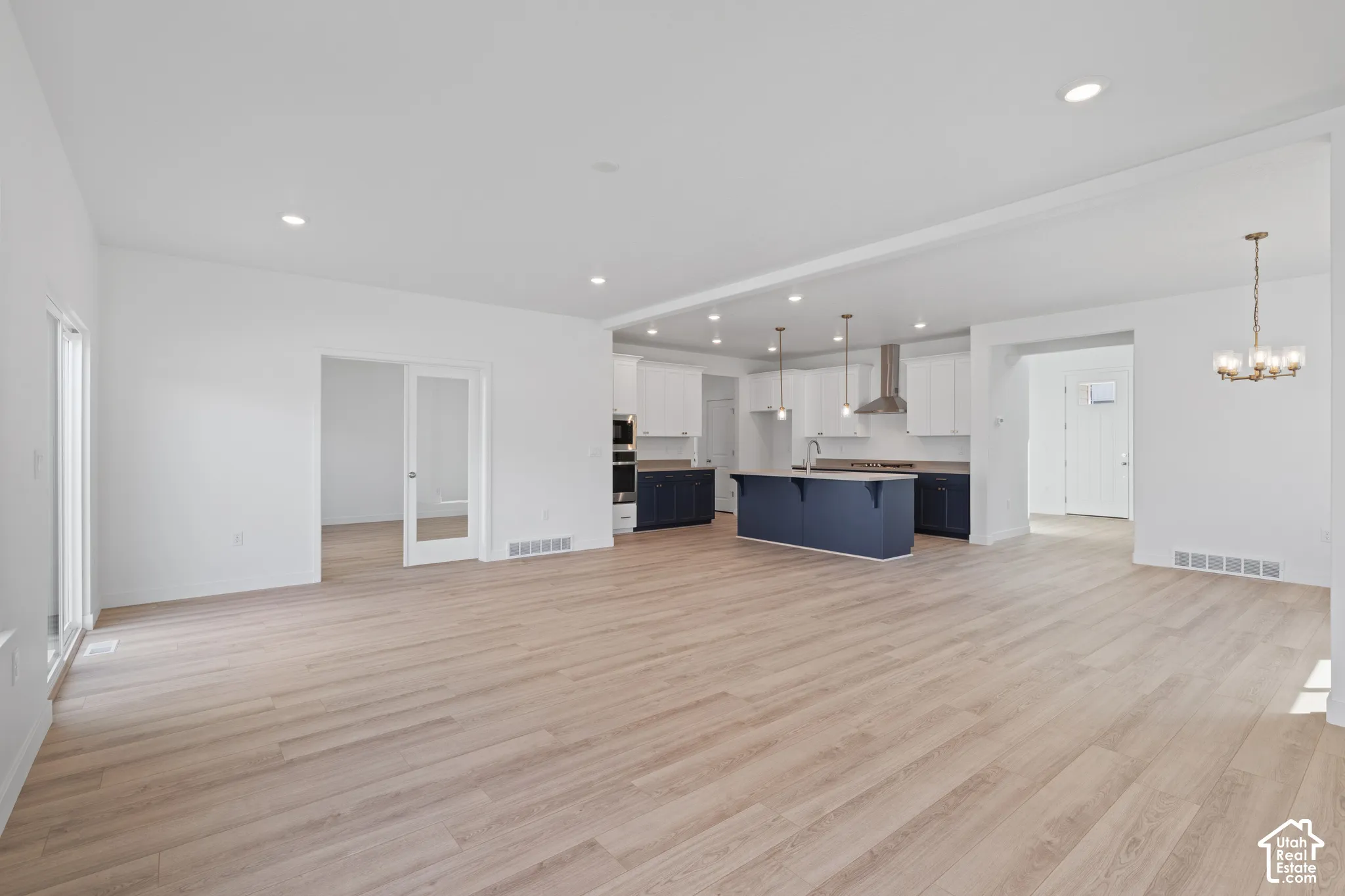Open-concept living area featuring light wood-finish flooring and recessed lighting