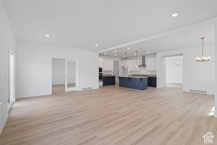 Open-concept living area featuring light wood-finish flooring and recessed lighting