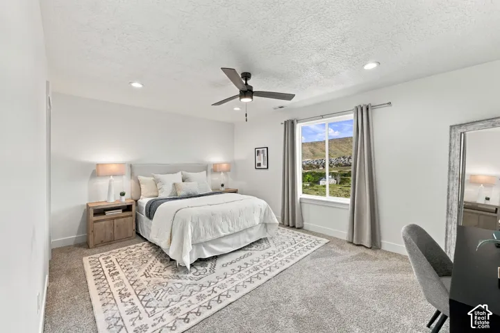 Recessed ceiling lighting, ceiling fan, and large window with mountain scenery