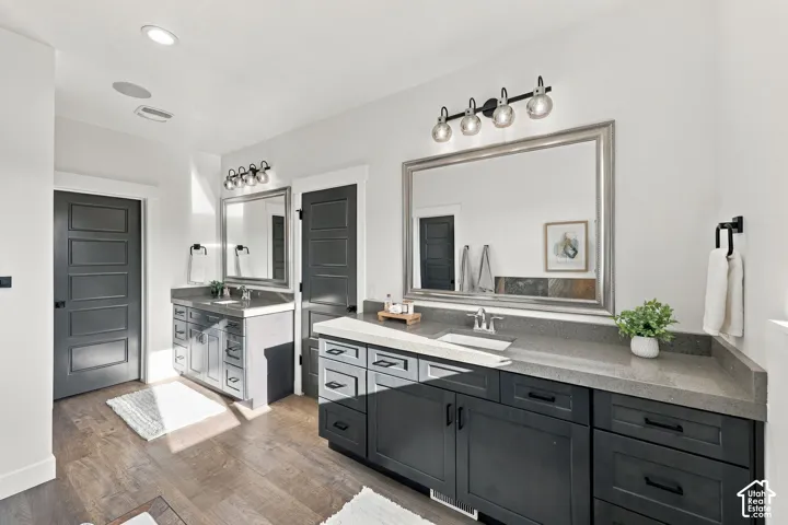 Dual vanities with integrated sinks, dark wood-finish cabinetry, and light grey countertops