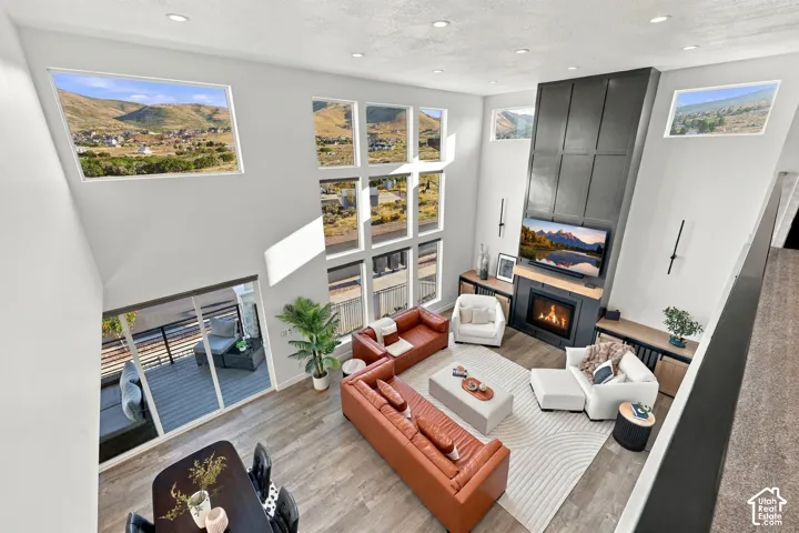 Two-story living area with high ceilings, a gas fireplace, and integrated custom shelving