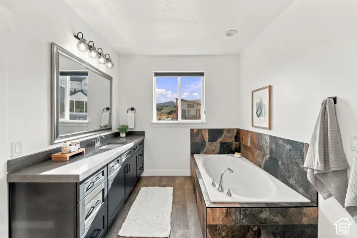 Dual vanity with dark cabinetry, integrated rectangular sinks, and a framed mirror