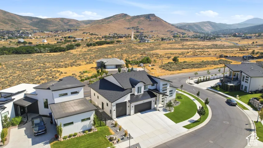 Modern architecture with a dark shingle roof, attached two-car garage, and concrete driveway