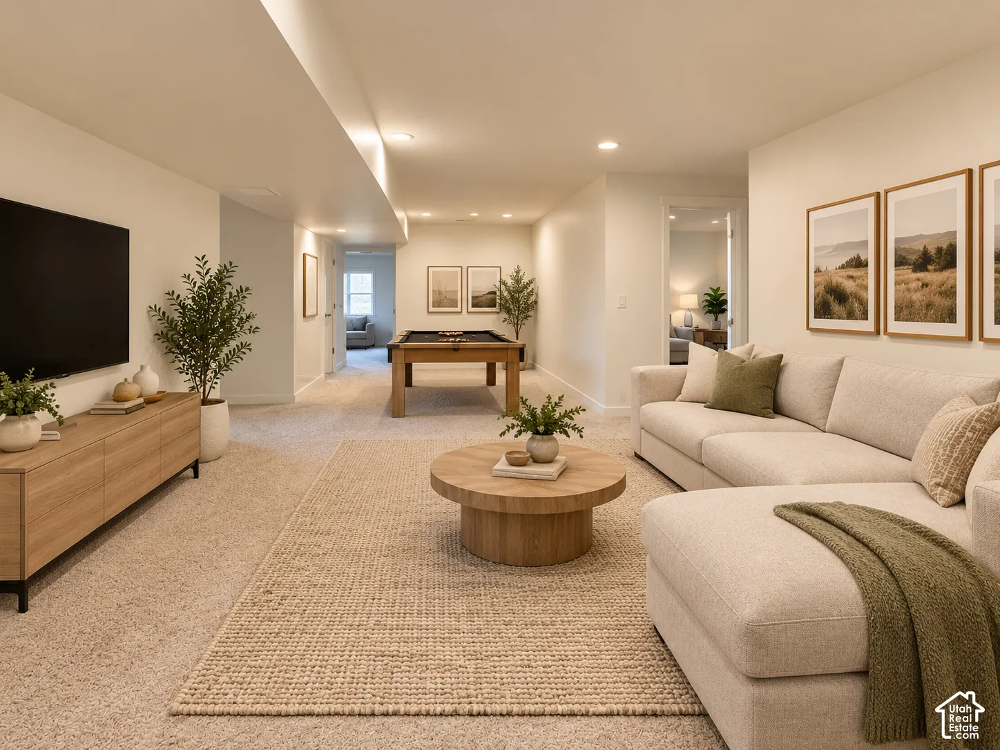 Expansive lower level featuring recessed lighting, plush carpeting, an open doorway, and a built-in media console