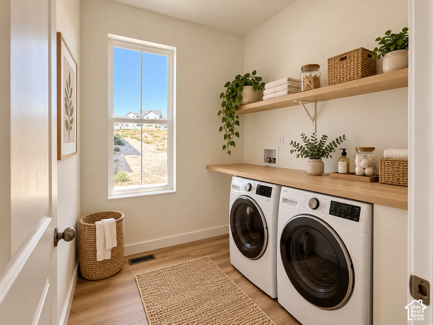 Laundry area featuring wood-finish flooring, a double window, built-in shelving, and a wood-finish countertop