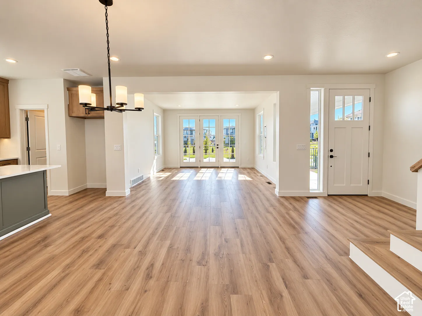 Wood-finish flooring throughout, with recessed lighting and a contemporary chandelier