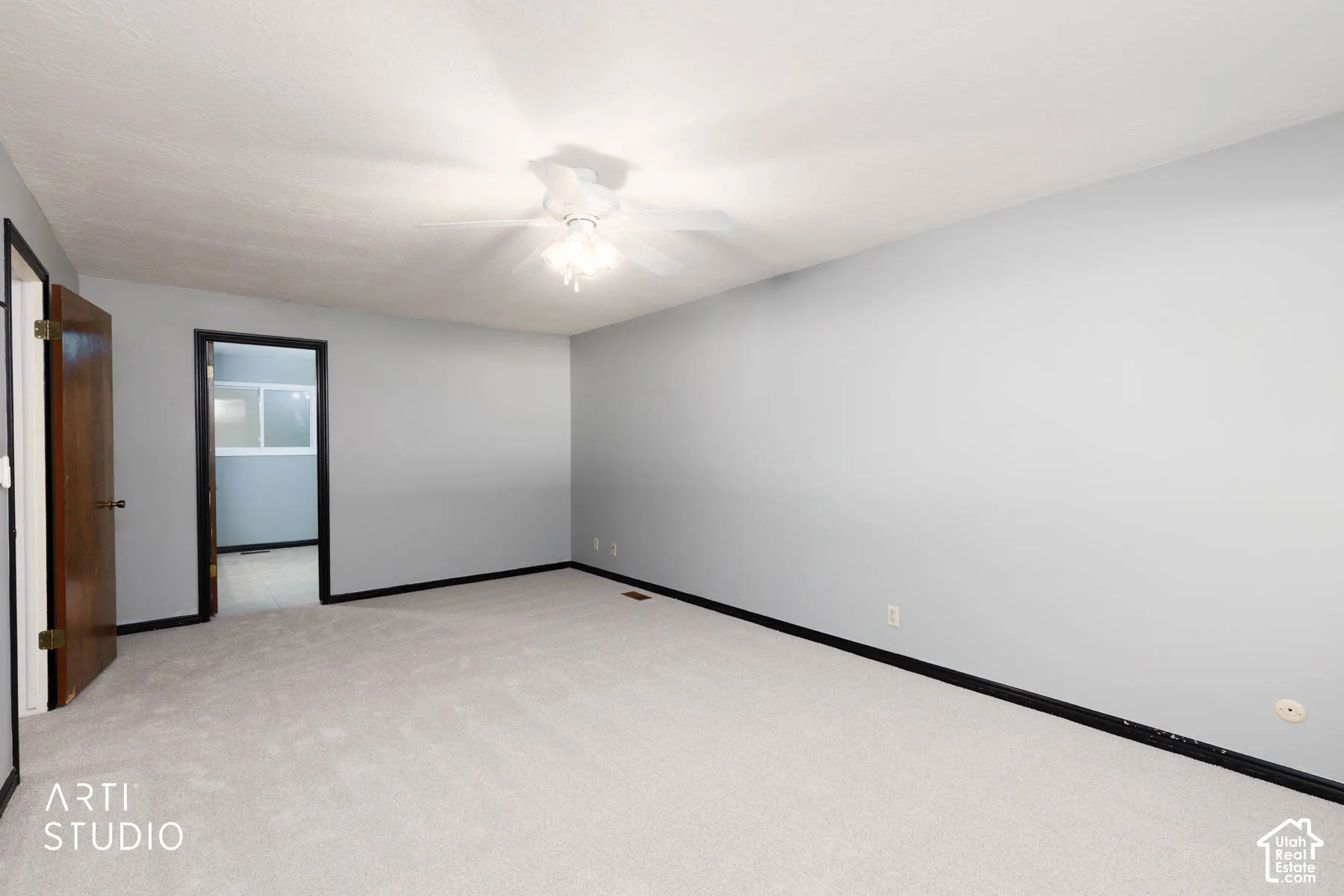 Light gray wall finish with a white ceiling, light gray carpet flooring, and a ceiling fan with integrated lighting