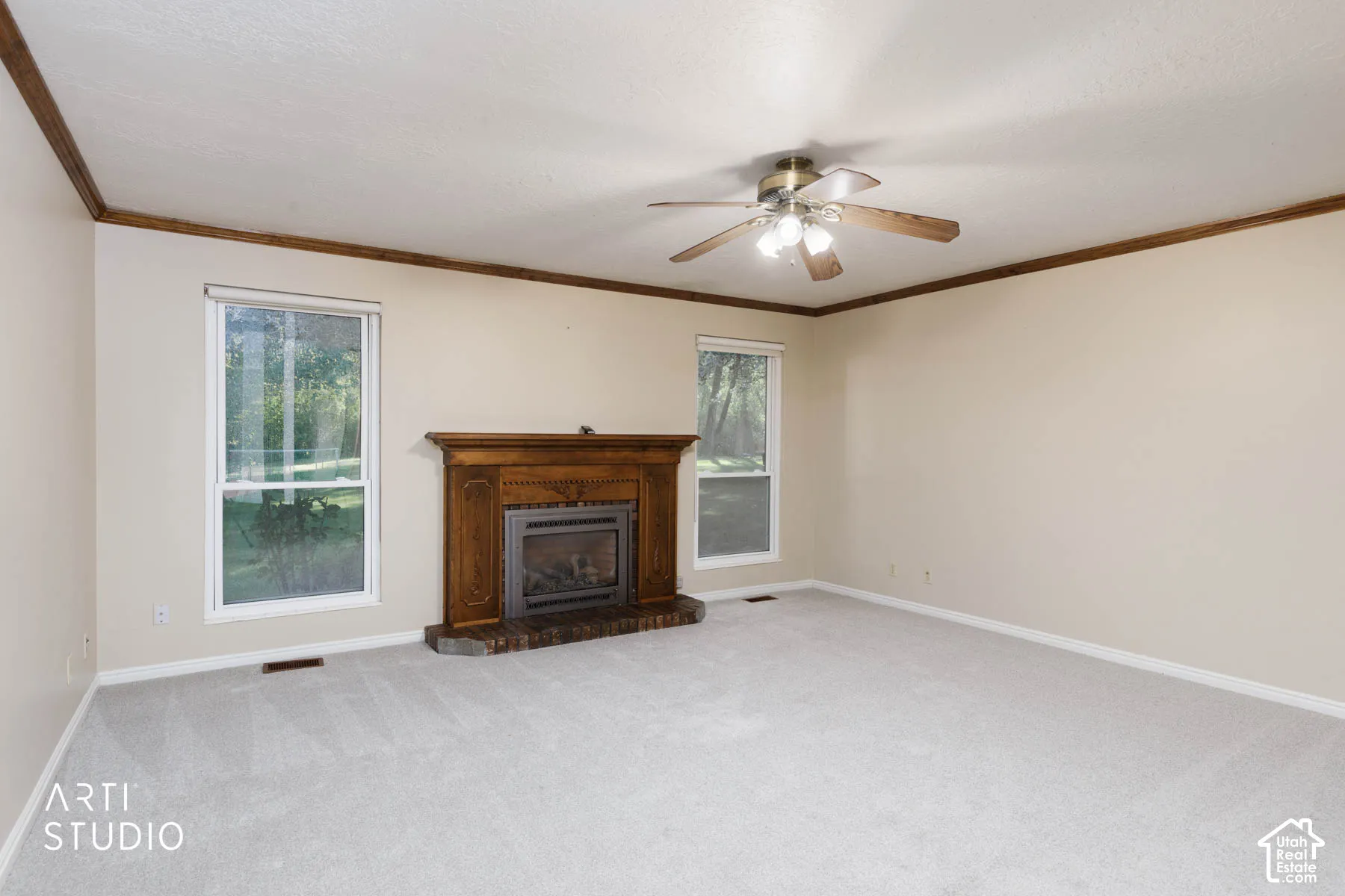 Spacious interior featuring a fireplace with ornate wood mantel, brick hearth, and two windows