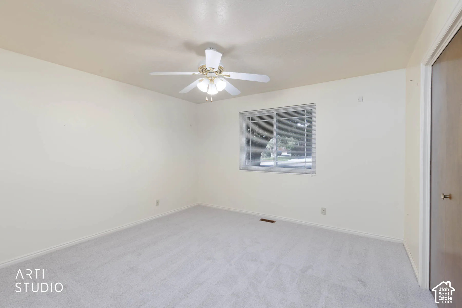 Neutral-toned walls, light-colored carpeting, a ceiling fan with integrated lighting, and a window with horizontal blinds