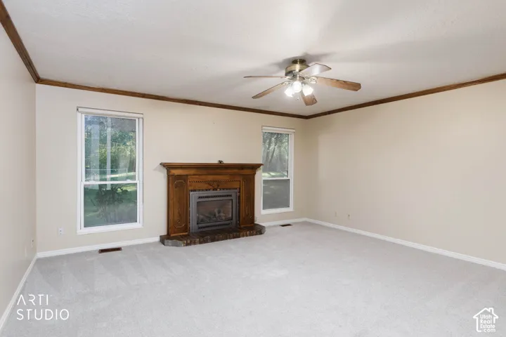 Spacious interior featuring a fireplace with ornate wood mantel, brick hearth, and two windows