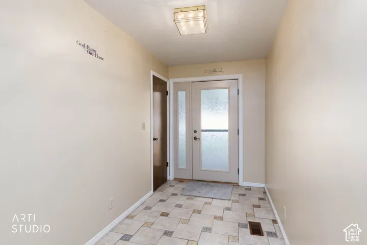 Dual entry doors with privacy glass, recessed ceiling light fixture, tile flooring, and a single paneled interior door