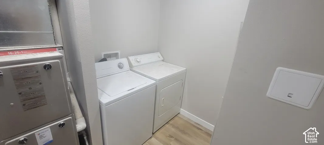 Laundry area with wood-finish flooring