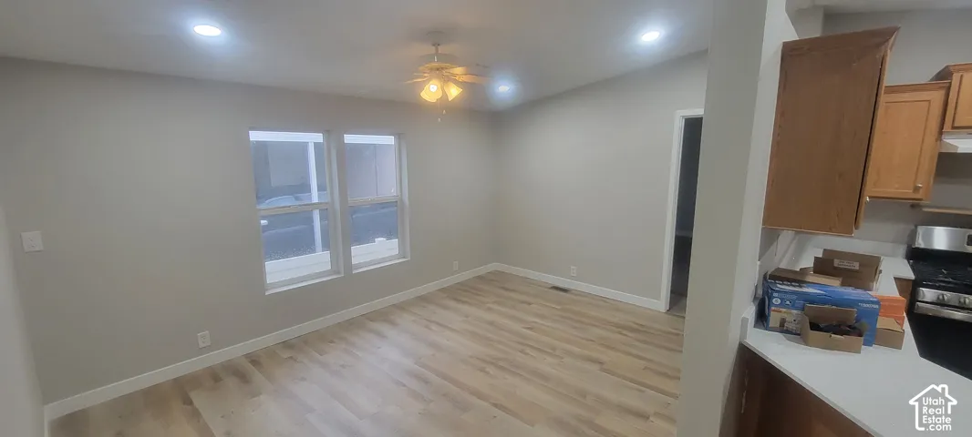 Recessed lighting, wood-finish flooring, ceiling fan, white trim, and multiple windows