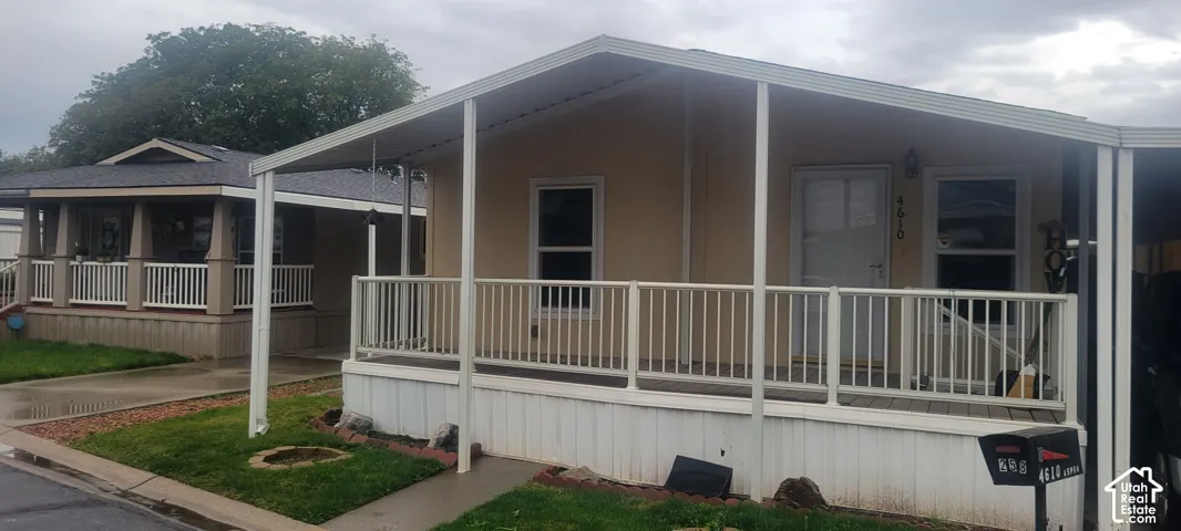 Covered front porch with white railings and support columns