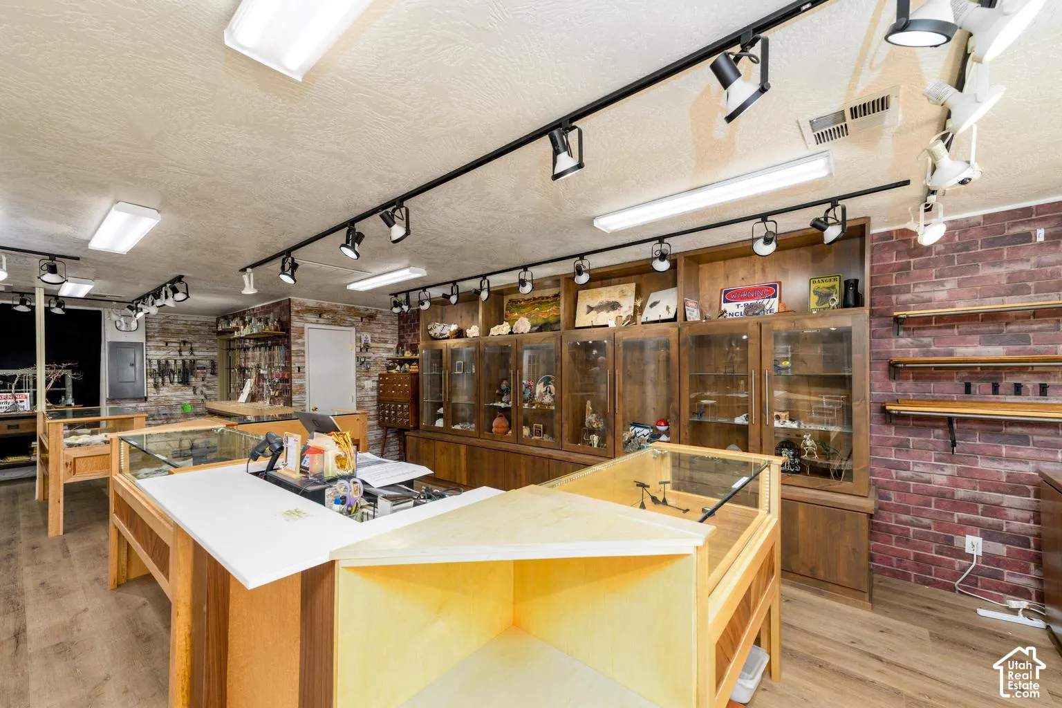 Wood-finish flooring with track lighting and recessed fluorescent fixtures
