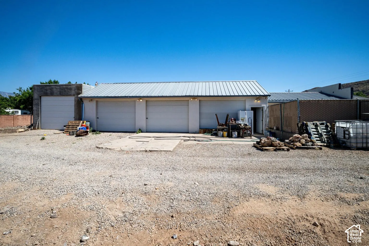 Building with multiple garage doors, metal roof, and concrete foundation