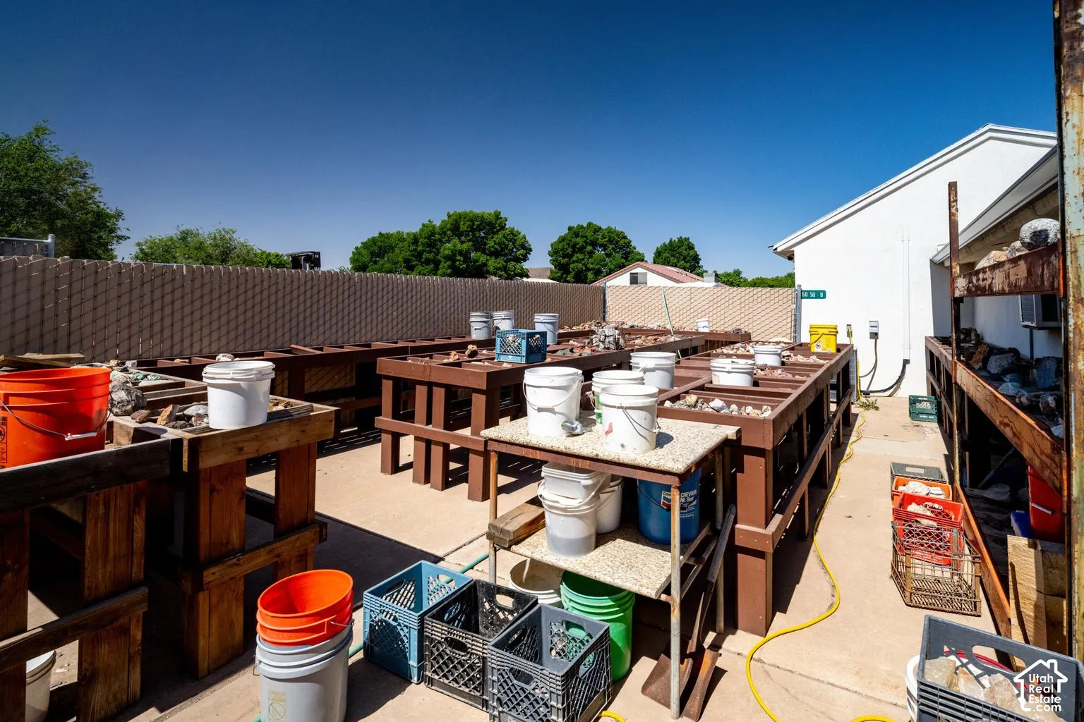 Concrete hardscaping with multiple wooden workbenches and shelving units