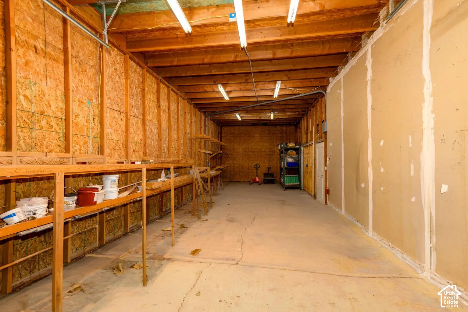 Concrete flooring with exposed wood joists and wall framing