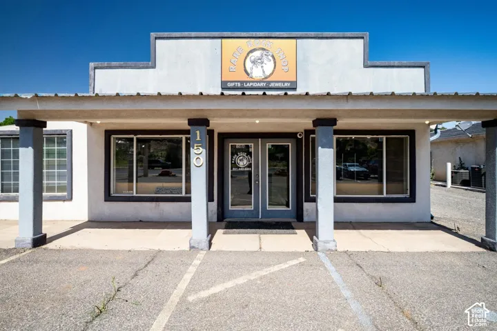 Commercial storefront with a covered entrance, large display windows, and a prominent exterior sign