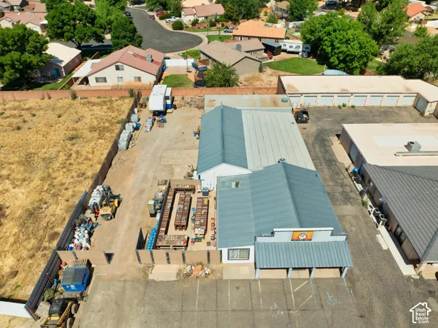 Commercial property featuring multiple buildings with metal roofing and a paved parking area