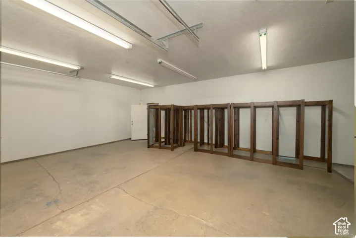 Spacious interior with concrete flooring and fluorescent overhead lighting