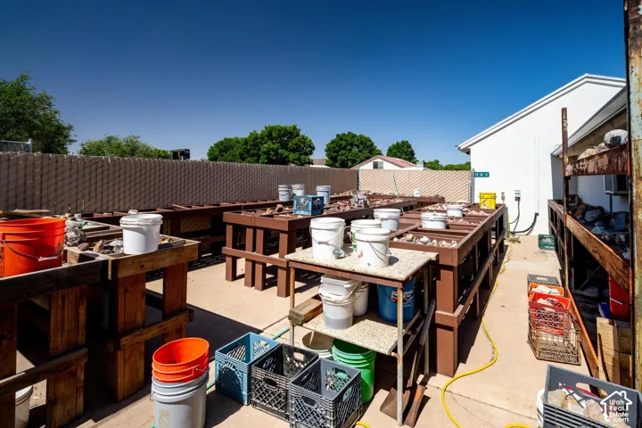 Concrete hardscaping with multiple wooden workbenches and shelving units