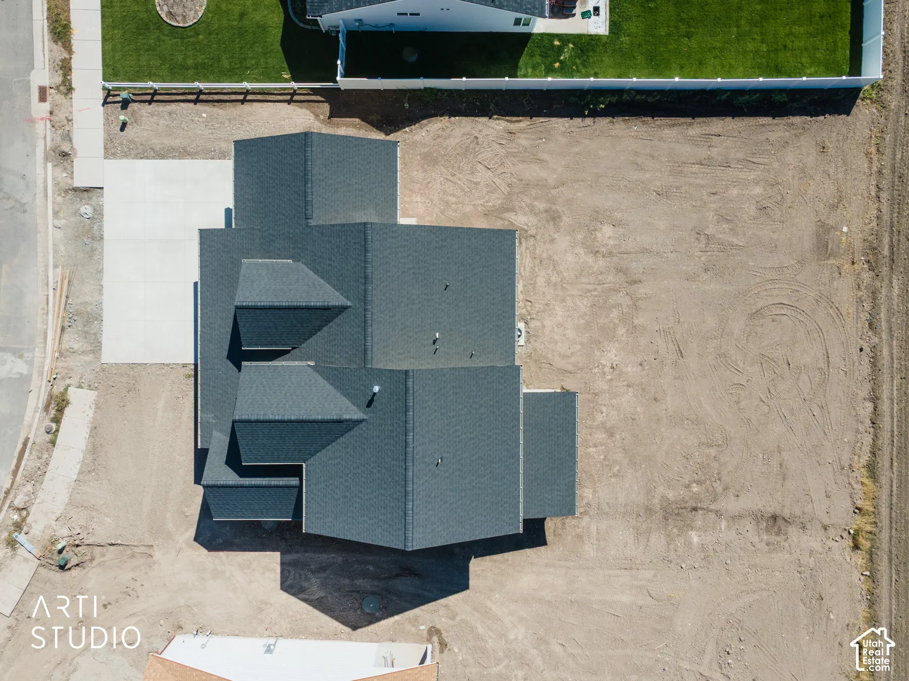 Newly constructed property featuring a dark shingle roof and a concrete driveway
