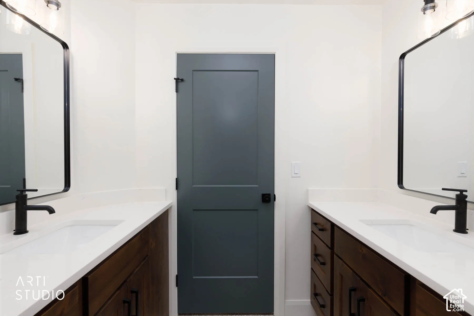 Dual vanities featuring built-in wood-finish cabinetry, integrated white sinks, and matte black fixtures