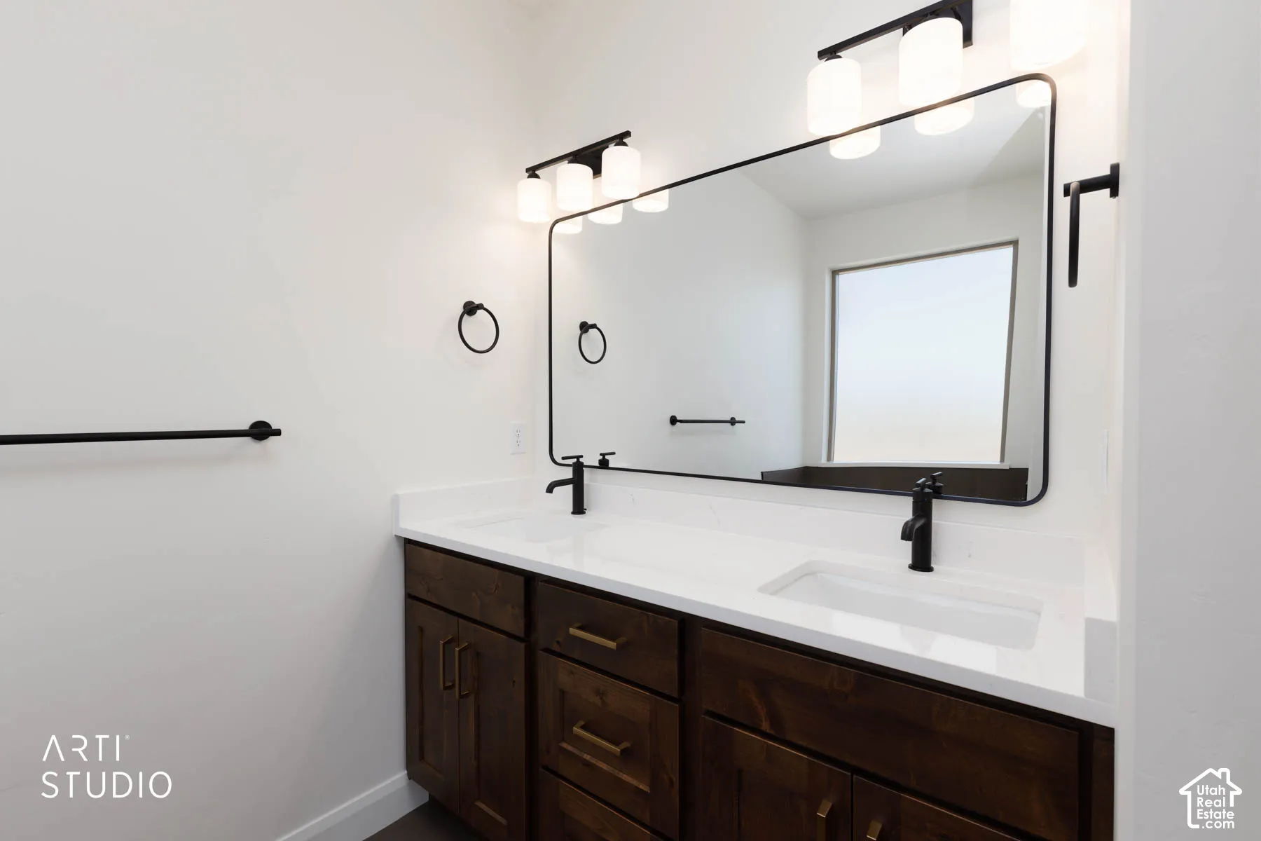 Dual vanity with white quartz countertops, integrated sinks, and dark wood-finish cabinetry