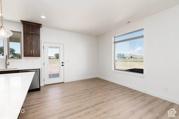 Wood-finish flooring throughout, white walls, and a large window providing ample ambient light