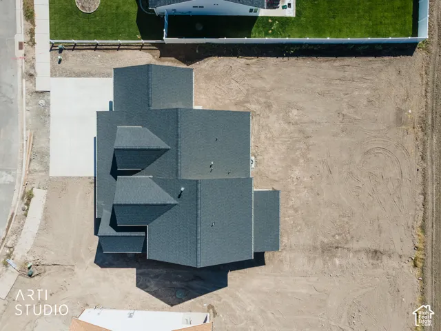Newly constructed property featuring a dark shingle roof and a concrete driveway