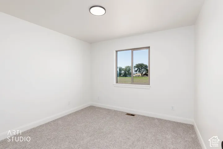 Upstairs bedroom 2 with neutral toned carpeting, white walls, flush mount ceiling light, and a horizontal window