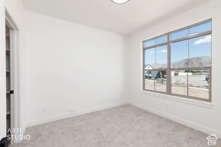 Front bedroom/office space with natural lighting and a walk in closet