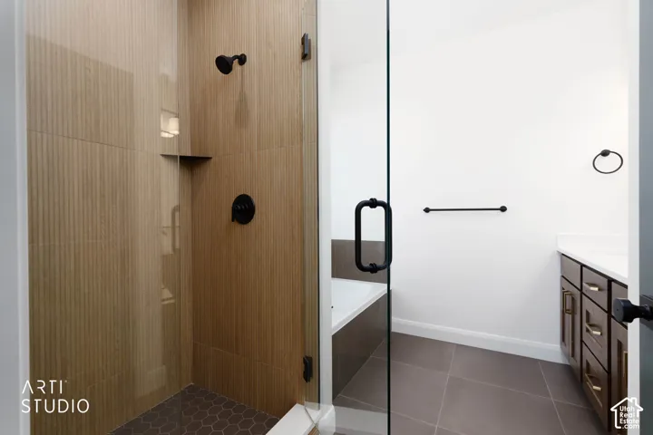 Enclosed shower with textured wall tile and custom glass
