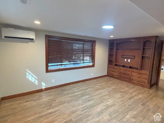 Built-in wood entertainment center with shelving and drawer storage in basement master suite