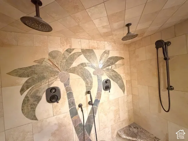 Shower with dual overhead rainfall showerheads, a palm tree mosaic accent, and a built-in bench