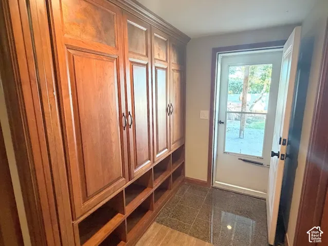 Built-in wood cabinetry with storage cubbies, durable tile flooring, and a glass-paneled exterior door