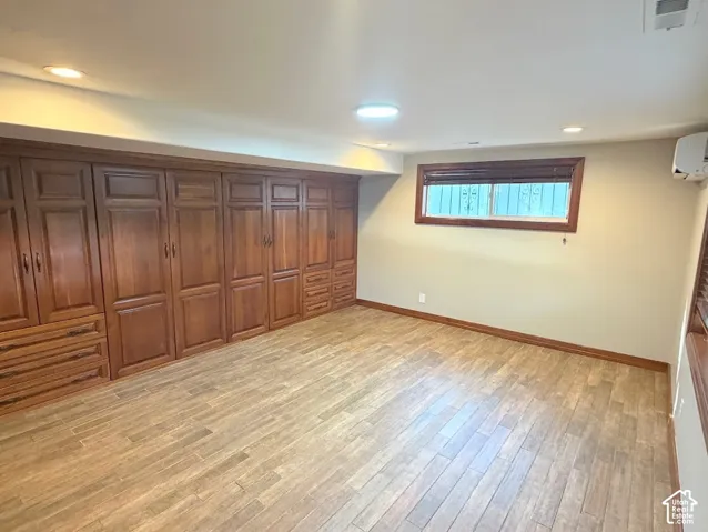 Extensive built-in wood cabinetry, wood-finish flooring, recessed lighting, and a window with wood trim