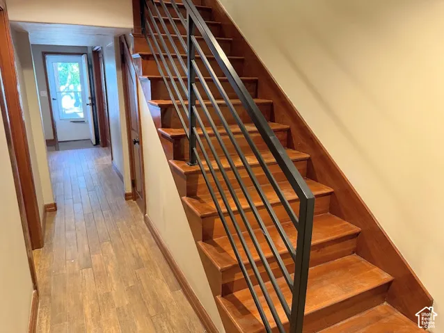 Hardwood staircase with metal railing and wood-finish flooring