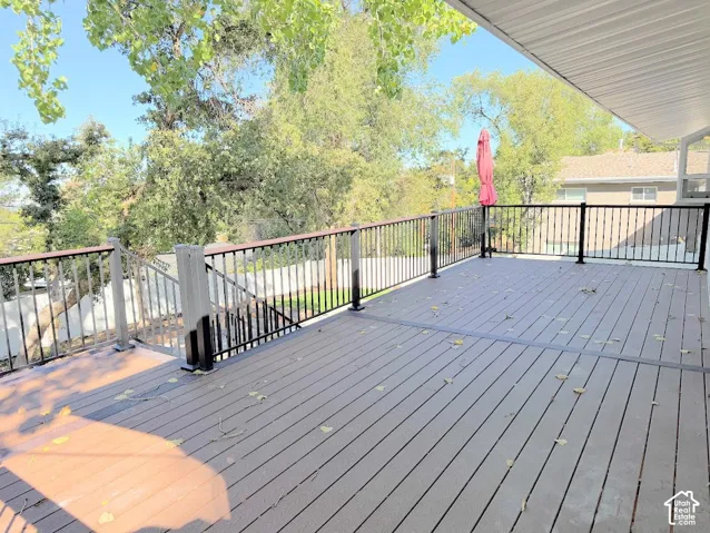 Expansive composite decking with black metal railings and a wood-finish top rail