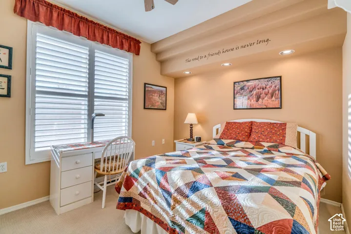 Recessed lighting, window with plantation shutters, ceiling fan, and carpeted flooring