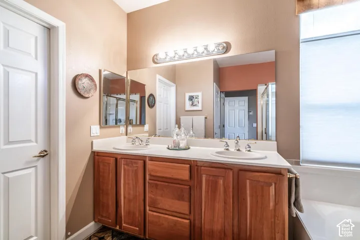 Dual vanity with wood-finish cabinetry, light-toned countertop, and undermount sinks