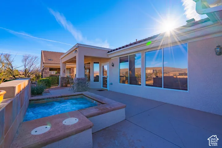 Integrated outdoor spa, stucco exterior, covered patio, large windows, and tile roof
